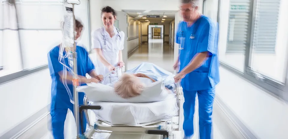 Image of providers pushing a patient in a stretcher