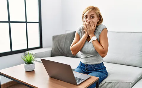 Woman covering her mouth looking embarassed