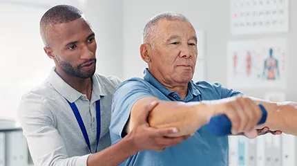 Image of man and therapist working on weights