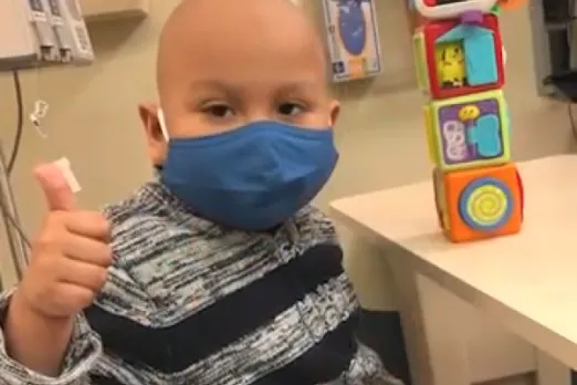 Sebastian, a patient of UMass Memorial Health, is wearing a mask and giving a thumbs up.